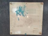 a sign with blue paint on it on a metal surface