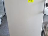 un réfrigérateur blanc sur lequel est collé un autocollant jaune, dans une cuisine