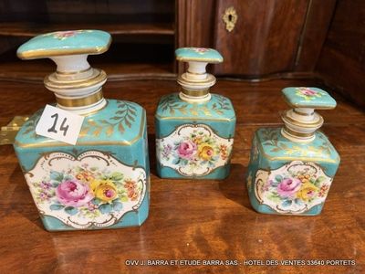 trois flacons de parfum posés sur une table à côté d'un meuble