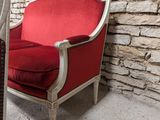 a red chair sitting in front of a stone wall