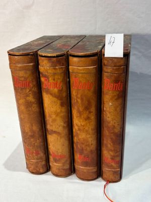 four old books are lined up in a row on a white surface