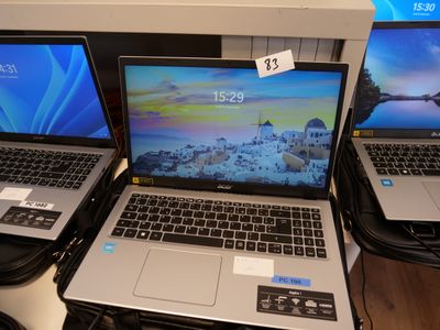 three laptops are sitting on a table with price tags on them