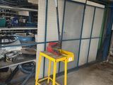 une petite table jaune dans un garage, avec un tabouret jaune
