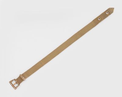 un gros plan sur une ceinture beige dotée d'une boucle métallique