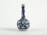 un vase bleu et blanc posé sur une surface blanche