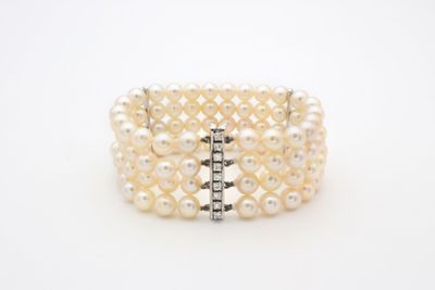 un gros plan sur un bracelet blanc orné de perles