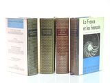 plusieurs livres sont alignés sur une surface blanche