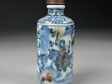 a small blue and white vase with flowers on it