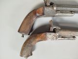 pair of silver plated pistols on a white surface with a white background