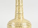 a yellow vase that is sitting on a white surface
