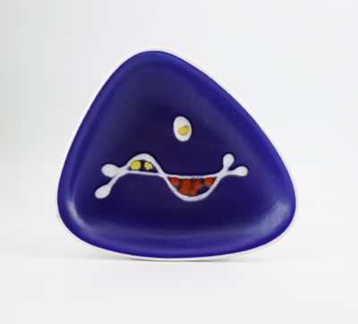 purple triangle shaped glass object with a smiling face on a white background