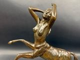 bronze statue of a woman riding a horse on a marble base