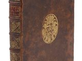 un vieux livre avec un emblème en or sur la couverture