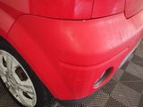 a close up of a red car that is parked in a garage