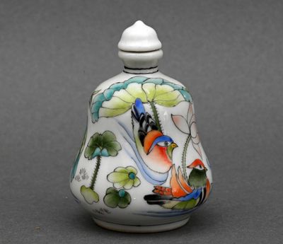 un petit vase avec un oiseau sur une table