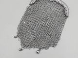 a close up of a chainmail purse on a white surface