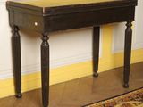 a black table with a brown top in a yellow room