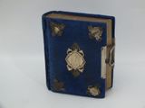 un petit livre bleu orné de motifs dorés