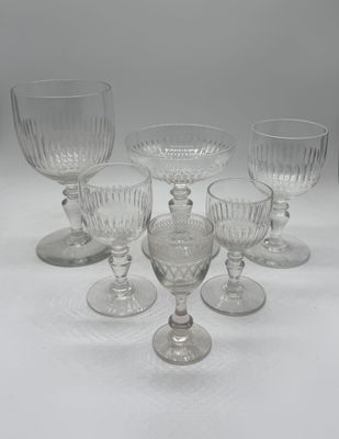six clear glass goblets sitting on top of a white table