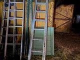 de nombreuses échelles appuyées contre un mur dans l'obscurité