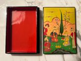 two small boxes with paintings on them on a table