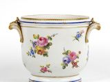 un vase blanc avec des fleurs sur une surface blanche