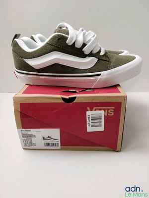 Des chaussures Vans Old Skool dans une boîte posée sur une surface blanche