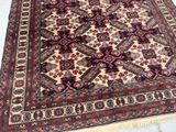 an oriental rug with a red and beige design on a white floor