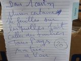 a note written on a piece of paper on top of a pile of boxes