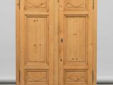 une armoire en bois à deux portes, surmontée d'un tiroir