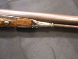 a gun that is sitting on a table next to a pair of knives
