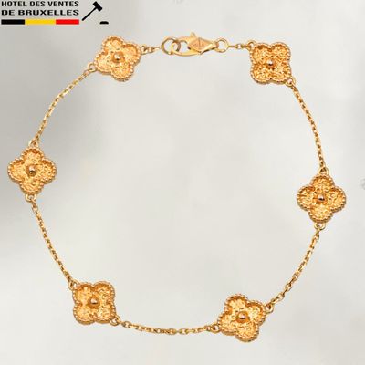 gros plan d'un bracelet en or sur fond blanc