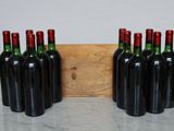 six bottles of wine are lined up in a row next to a cutting board