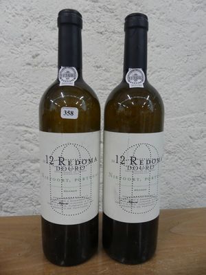 deux bouteilles de vin posées sur une table l'une à côté de l'autre