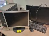 two computer monitors sitting on a desk with a keyboard and mouse