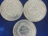 three silver coins, one of which has a crown and one of which has a crown on it