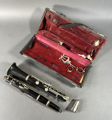 une clarinette et un stylo dans un étui posé sur une table