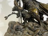 bronze statue of a man with a gun and a dog
