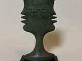 an image of a sculpture of a face on a black base