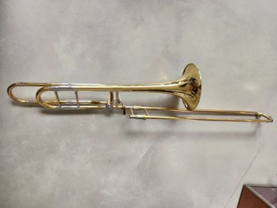 an old brass trombone sitting on top of a white table