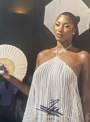 une femme en robe blanche tenant un éventail et un éventail