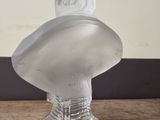 a clear glass bust of a man on a wooden table