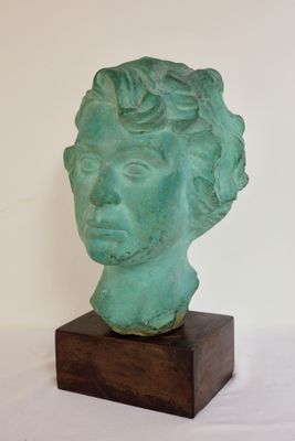 statue représentant la tête d'une femme, posée sur un socle en bois