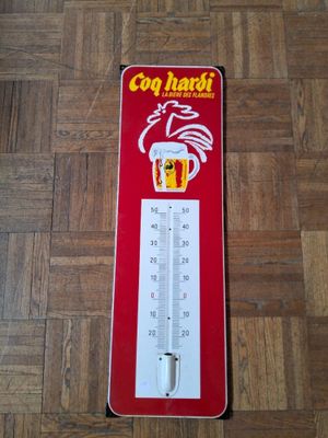 un thermomètre rouge et blanc posé sur un parquet