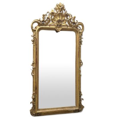 un miroir à cadre doré orné d'un motif décoratif dans sa partie supérieure