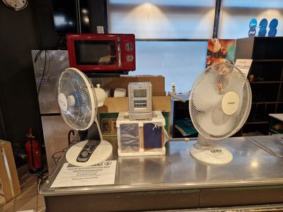deux ventilateurs posés sur le comptoir du magasin