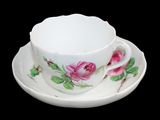 une tasse et une soucoupe blanches ornées de fleurs roses
