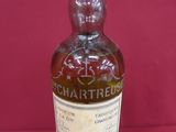 an old bottle of whisky sitting on a red surface