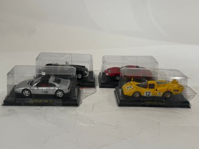 trois petites voitures dans une vitrine posée sur une surface blanche