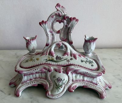 a white and pink table with a vase and a candle holder